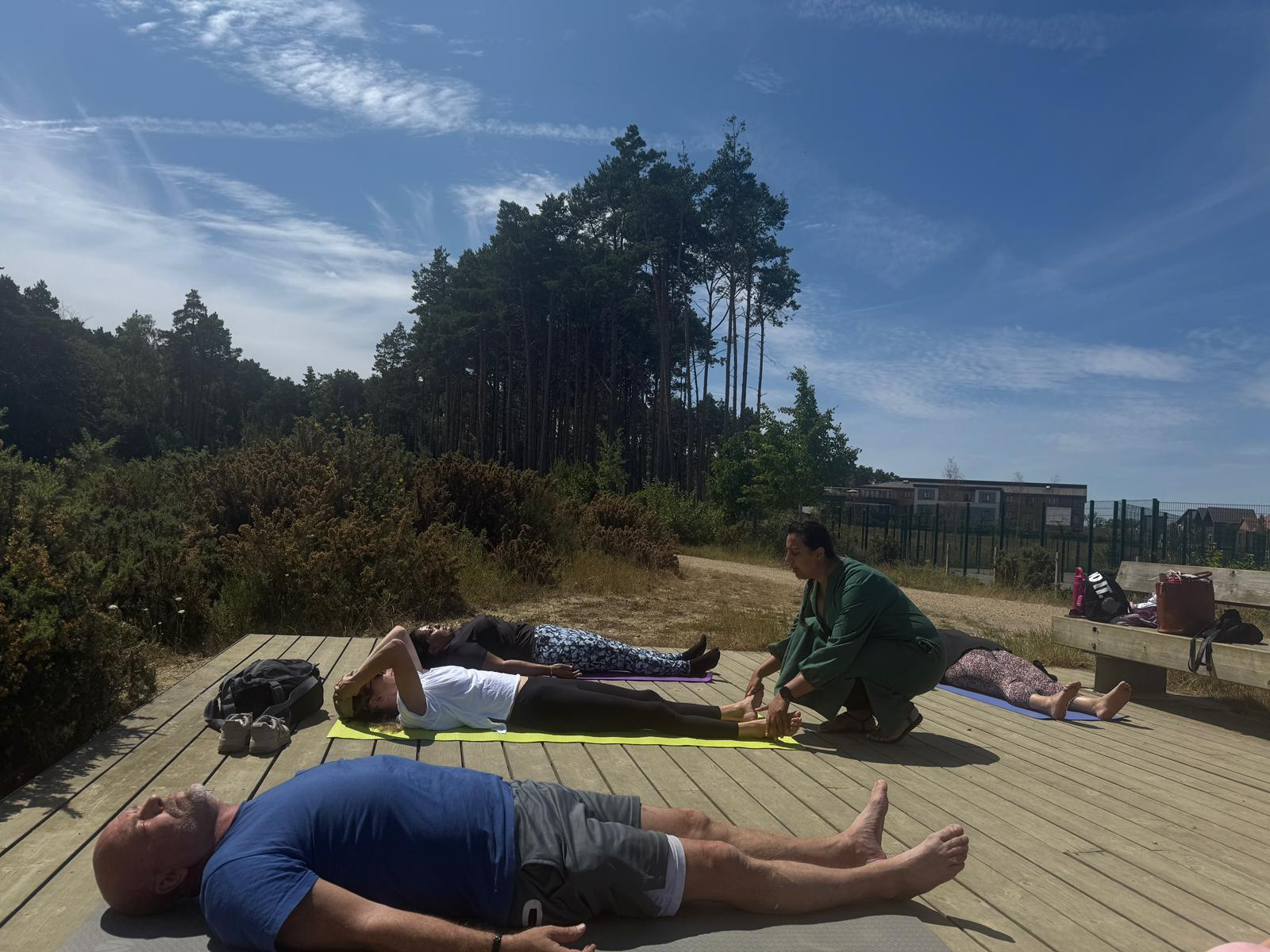 Participants lying on yoga mats outdoors during a guided forest walk at the Berkshire Forest Retreat by journey with Nkita, relaxing and connecting with nature.