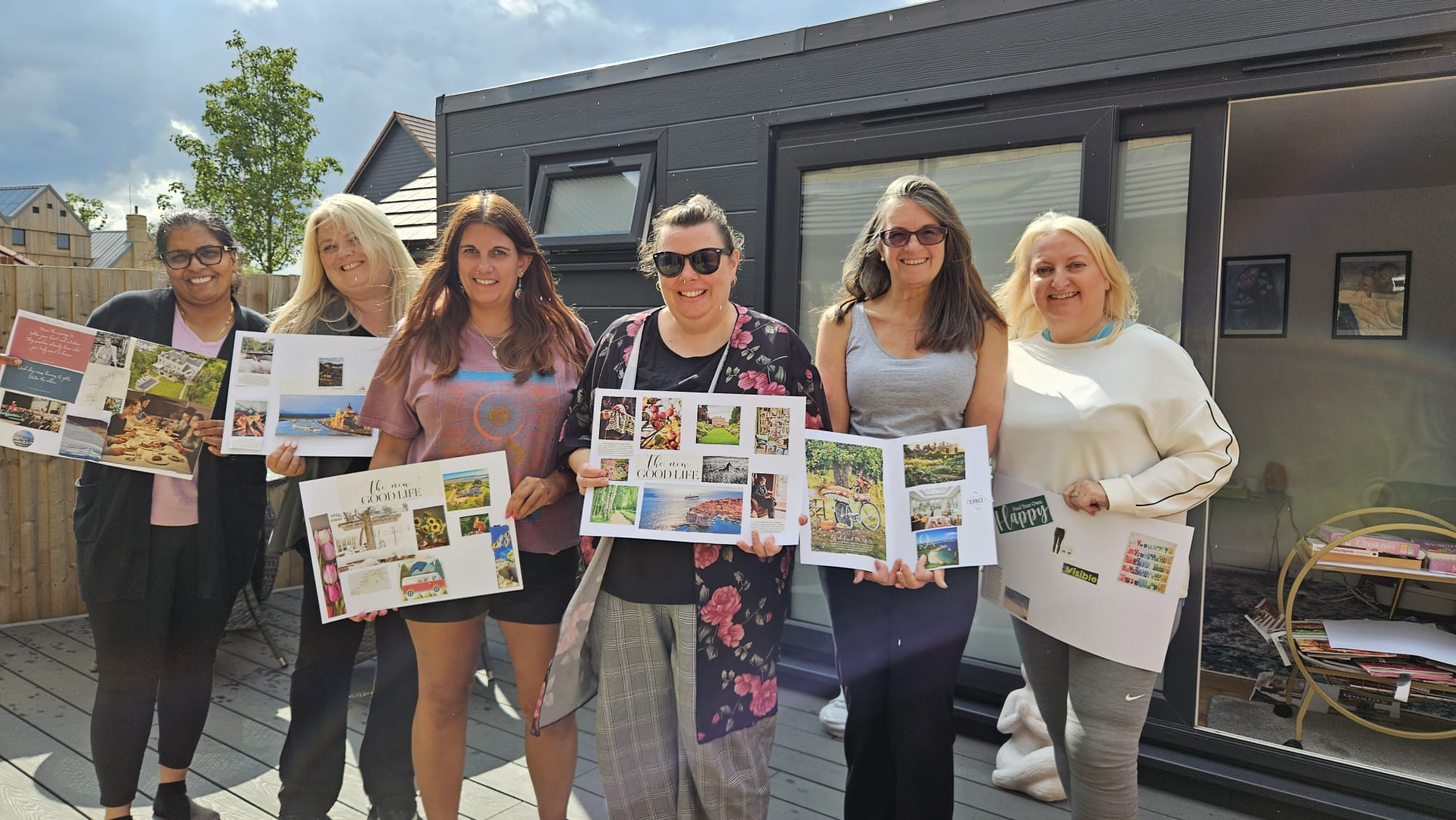 Participants proudly displaying their completed vision boards during the Forest Retreat by Nikita Thakrar in Berkshire, sharing their personal growth insights.