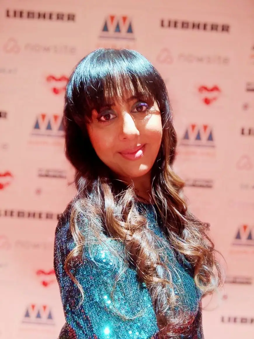 Portrait of Nikita Thakrar speaker for schools Berkshire UK, award-winning educator and founder of Journey from Karma to Dharma, standing in a relaxed indoor setting.