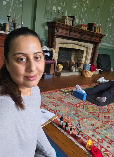Nikita Thakrar, facilitator of a luxury wellness retreat in Berkshire, UK, sitting in a calm, creative space prepared for meditation, journaling, and soulful reflection